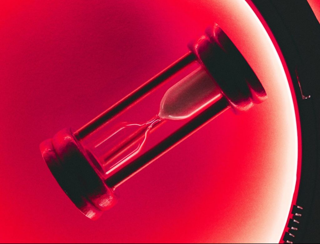 An hourglass on a red background