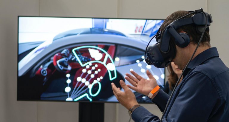 A man using a VR headset to drive a car in the Metaverse